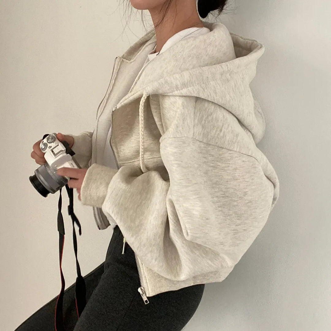 "Kvinnors trendig hoodie med dragkedja och sluttande axlar i modern passform, mångsidig design i olika färger."