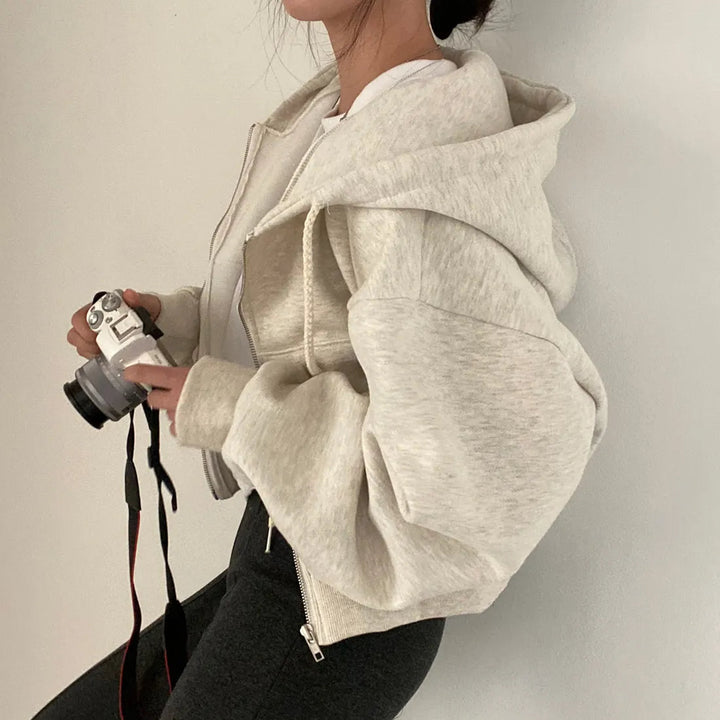 "Kvinnors trendig hoodie med dragkedja och sluttande axlar i modern passform, mångsidig design i olika färger."