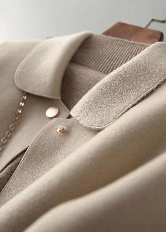 "Kvinnors ullkappa med Peter Pan-krage och fickor, elegant beige design, perfekt för höst och vinter."