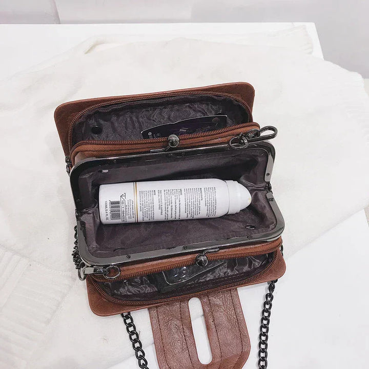 "Kvinnors vintage crossbody väska i svart PU-läder med spänne, elegant och kompakt med justerbar axelrem."
