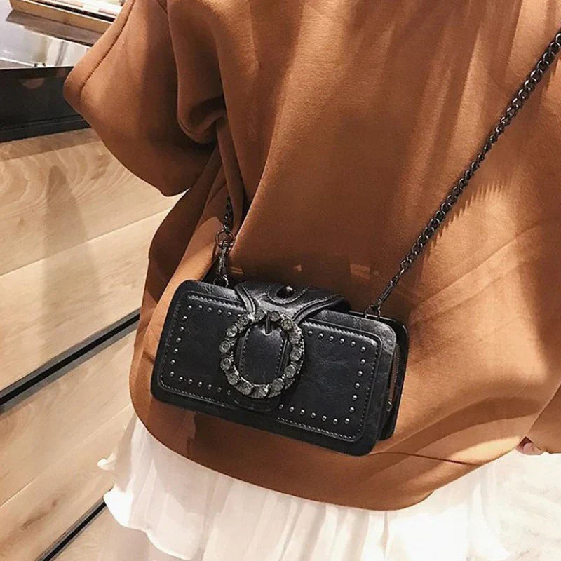 "Kvinnors vintage crossbody väska i svart PU-läder med spänne, elegant och kompakt med justerbar axelrem."