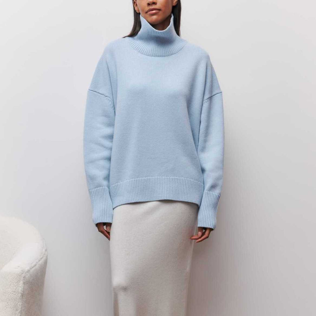 "Kvinnors vintertröja med rullhals, mjuk textur i klassiska färger som beige och blå, perfekt för kallt väder."