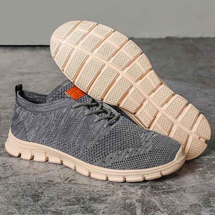 "Lätta andningsbara herrsneakers med stilren design, textil och syntetmaterial i svart, grå och blå färg."