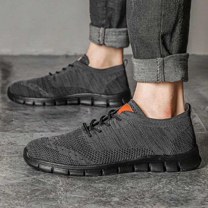 "Lätta andningsbara herrsneakers med stilren design, textil och syntetmaterial i svart, grå och blå färg."