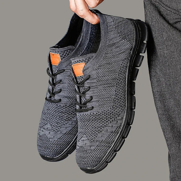 "Lätta andningsbara herrsneakers med stilren design, textil och syntetmaterial i svart, grå och blå färg."