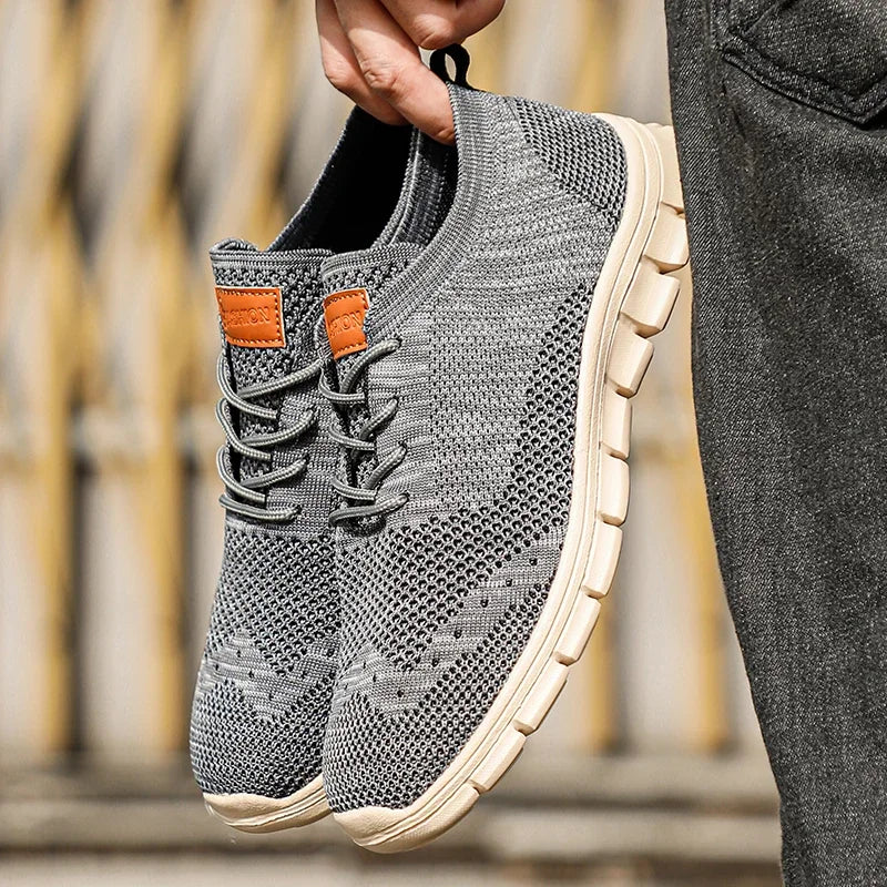 "Lätta andningsbara herrsneakers med stilren design, textil och syntetmaterial i svart, grå och blå färg."