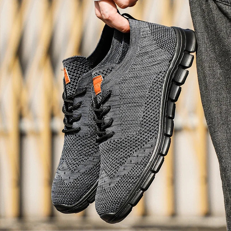 "Lätta andningsbara herrsneakers med stilren design, textil och syntetmaterial i svart, grå och blå färg."