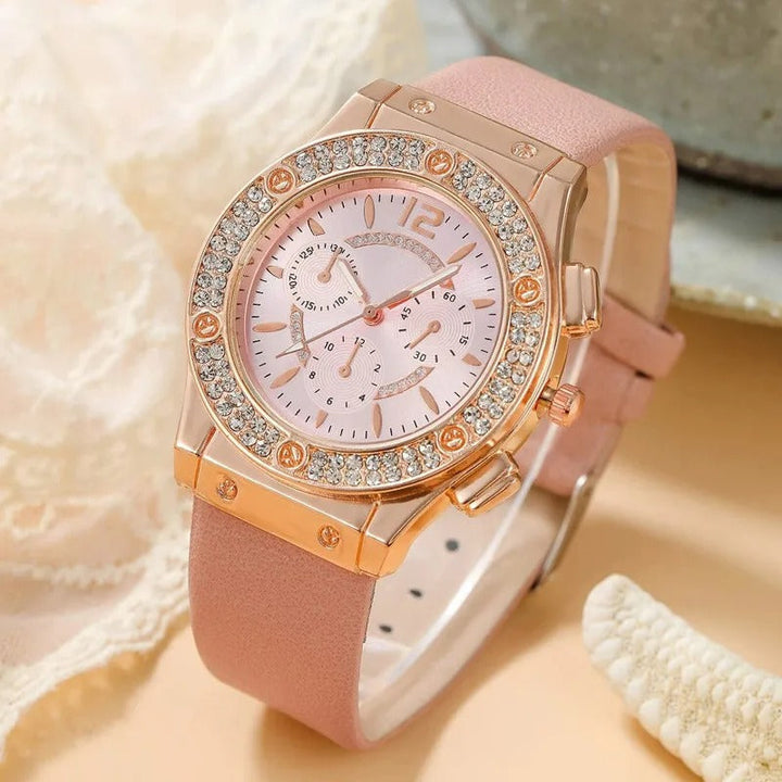 "Lyxig damklocka med strass, rosa band och kvartsurverk. Elegant och gnistrande design för en sofistikerad look."