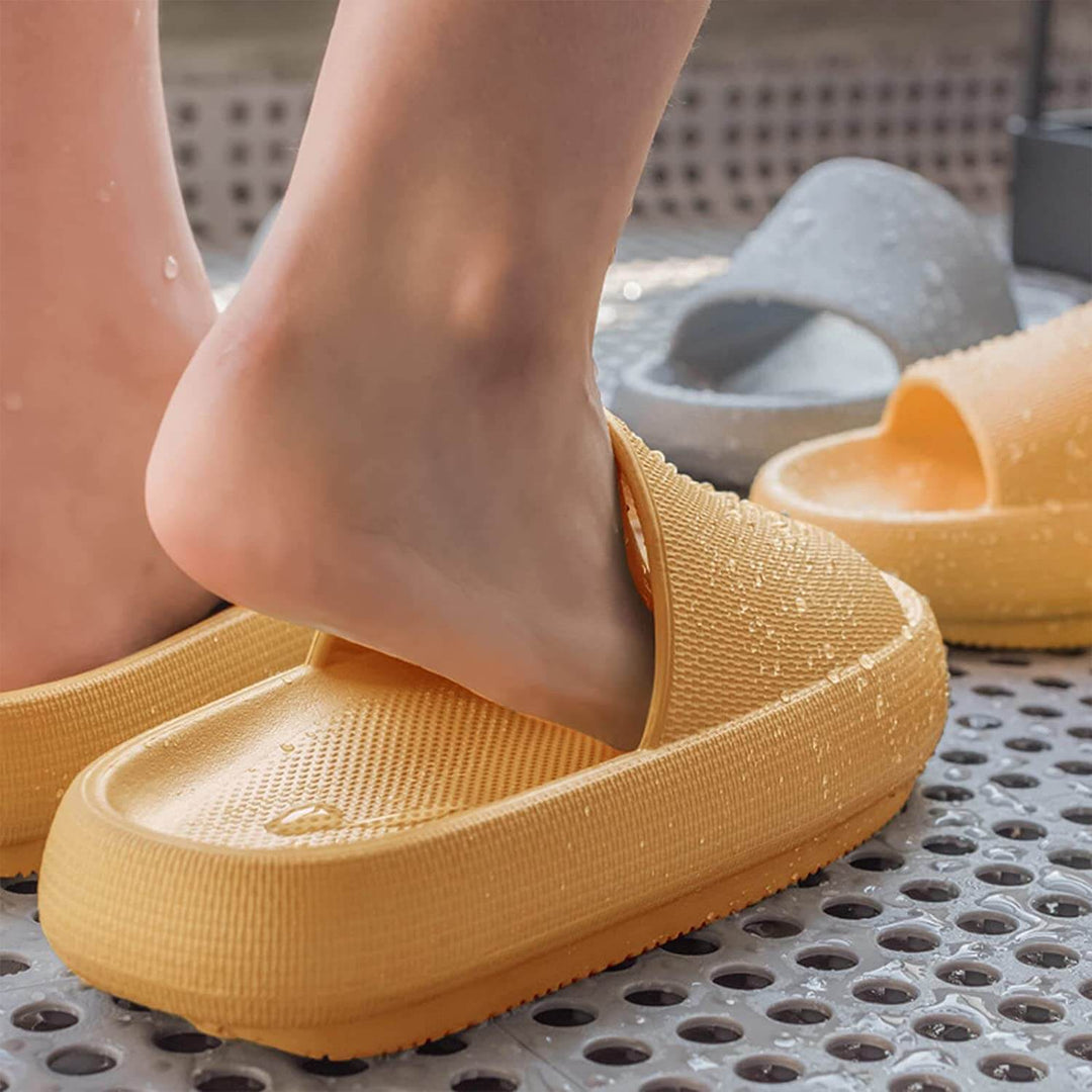 "Mjuka kuddtofflor för kvinnor i olika färger, ergonomiskt utformade för smärtlindring och halkfritt grepp."