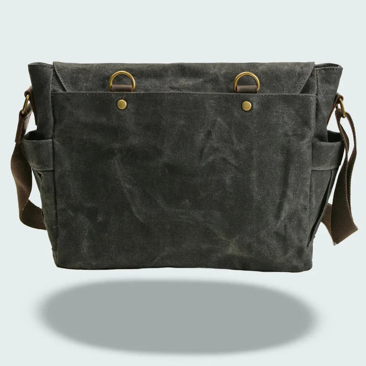 "Mäns vintage messenger-väska i oljevaxad läder med justerbar rem och flera fack, framifrån perspektiv."