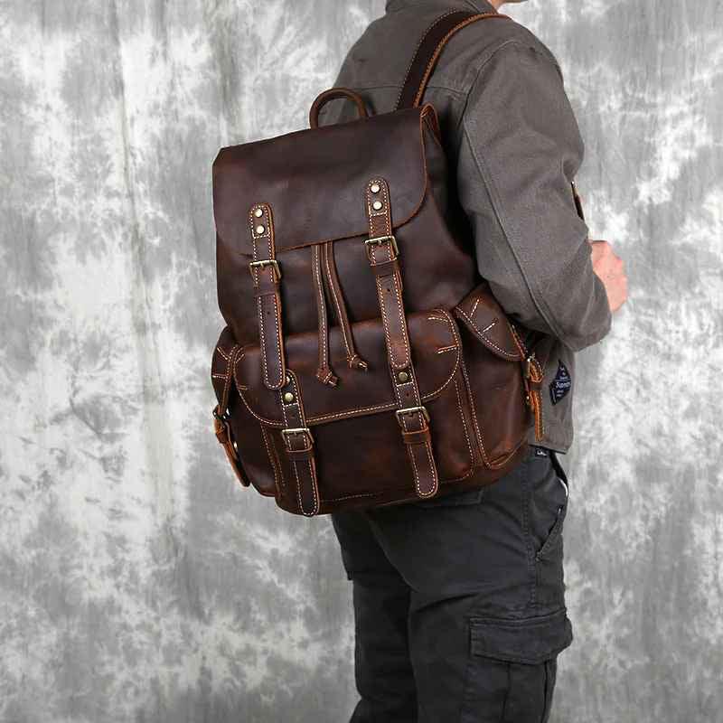 "Mäns vintage ryggsäck i läder med rymlig interiör, flera fack och justerbara axelremmar i elegant brun ton."