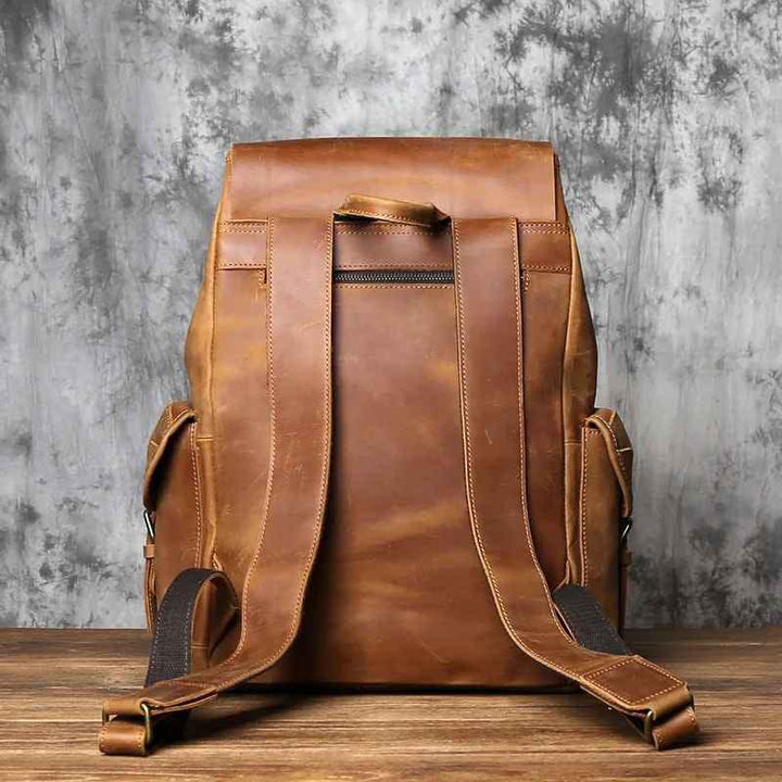 "Mäns vintage ryggsäck i läder med rymlig interiör, flera fack och justerbara axelremmar i elegant brun ton."