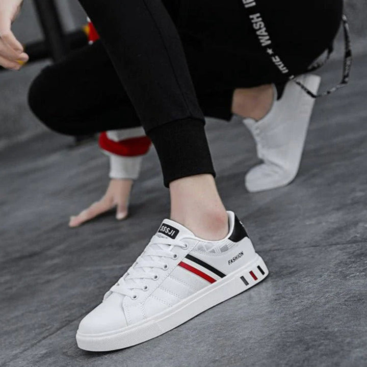 Modern herrsneakers med syntetisk ovandel, vadderad häl och halkfri sula, idealiska för sport och vardagsanvändning.