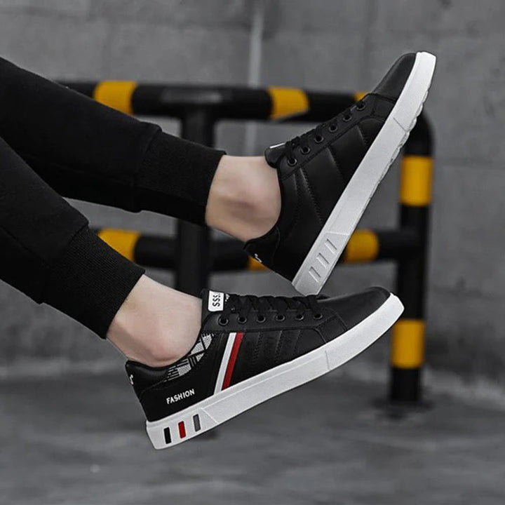 Modern herrsneakers med syntetisk ovandel, vadderad häl och halkfri sula, idealiska för sport och vardagsanvändning.