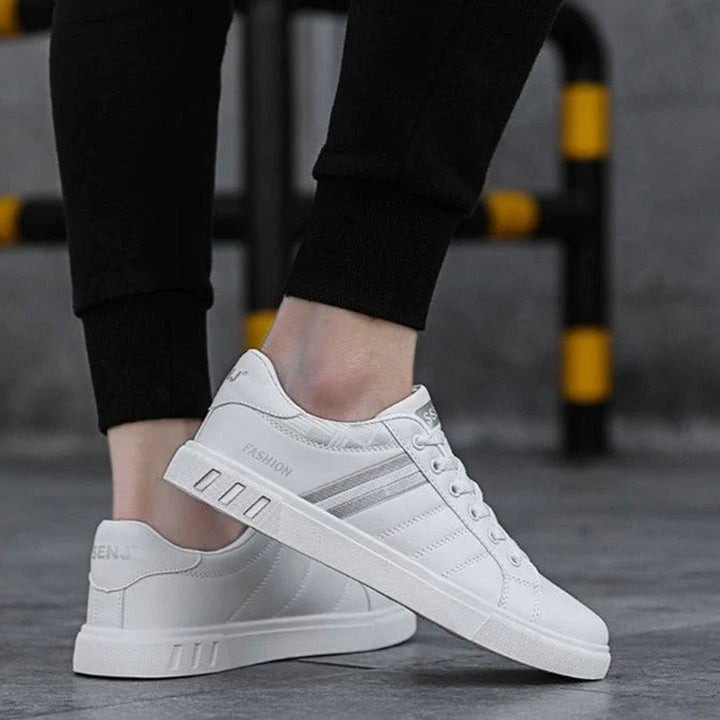 Modern herrsneakers med syntetisk ovandel, vadderad häl och halkfri sula, idealiska för sport och vardagsanvändning.