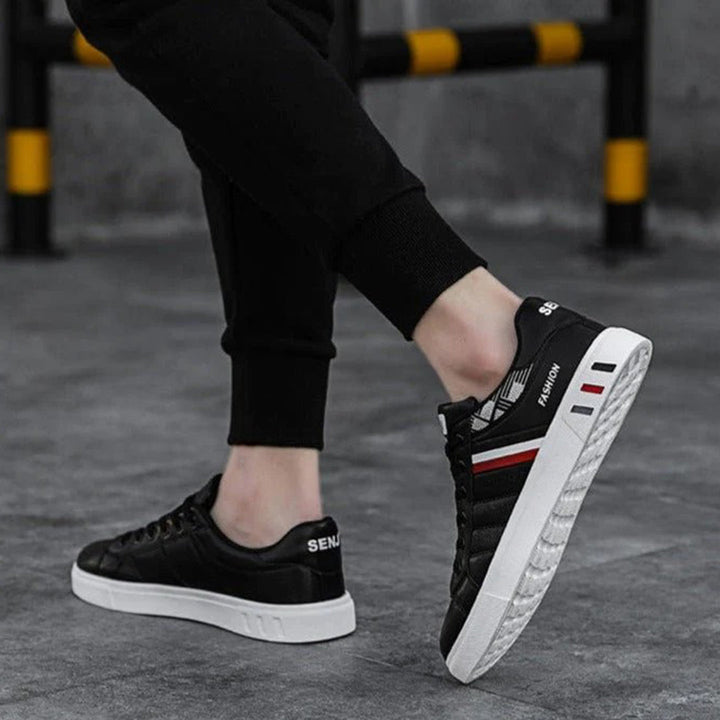 Modern herrsneakers med syntetisk ovandel, vadderad häl och halkfri sula, idealiska för sport och vardagsanvändning.