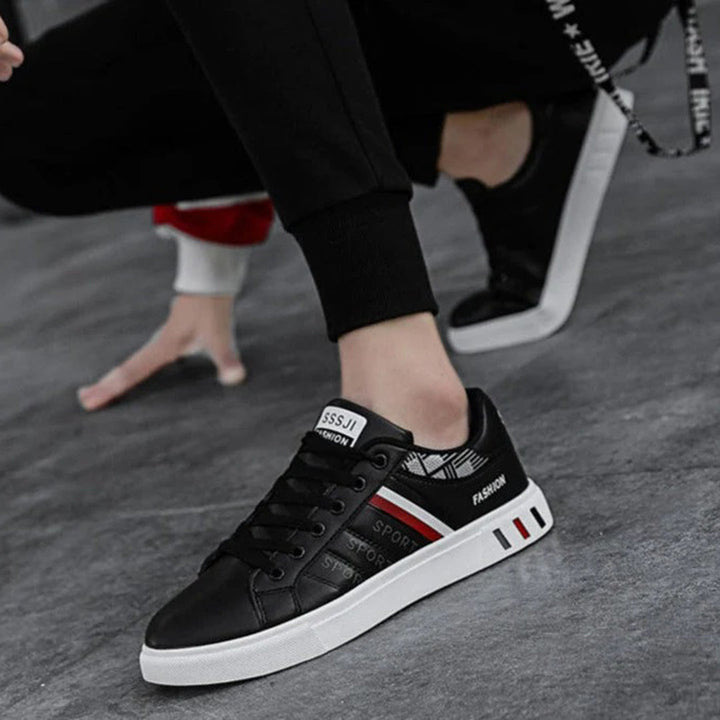 Modern herrsneakers med syntetisk ovandel, vadderad häl och halkfri sula, idealiska för sport och vardagsanvändning.