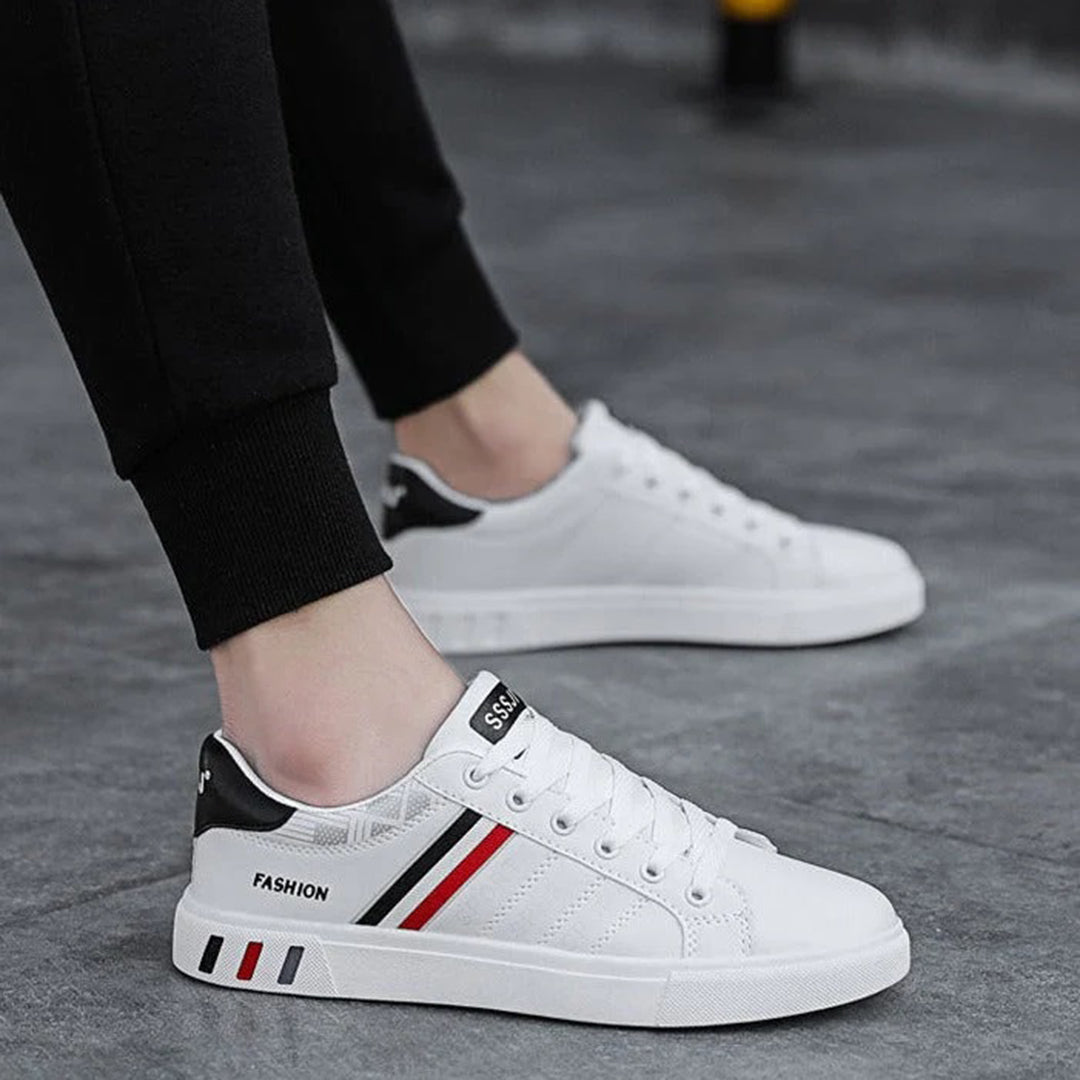 Modern herrsneakers med syntetisk ovandel, vadderad häl och halkfri sula, idealiska för sport och vardagsanvändning.