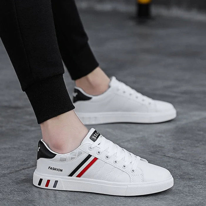 Modern herrsneakers med syntetisk ovandel, vadderad häl och halkfri sula, idealiska för sport och vardagsanvändning.