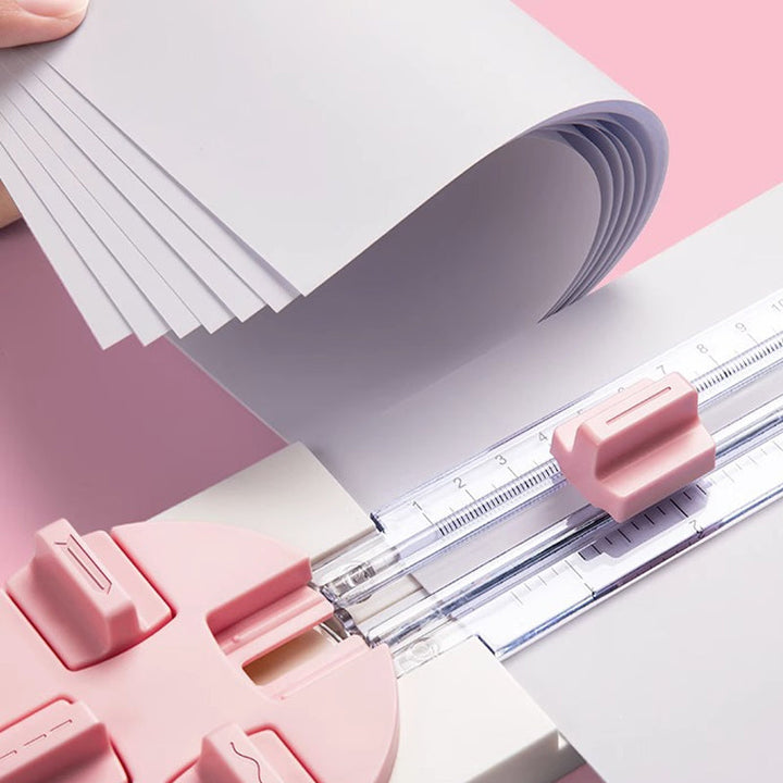 "Multifunktionell 4-i-1 pappersskärare i rosa och blå plast, perfekt för hantverk som scrapbooking med precisionsskärning."