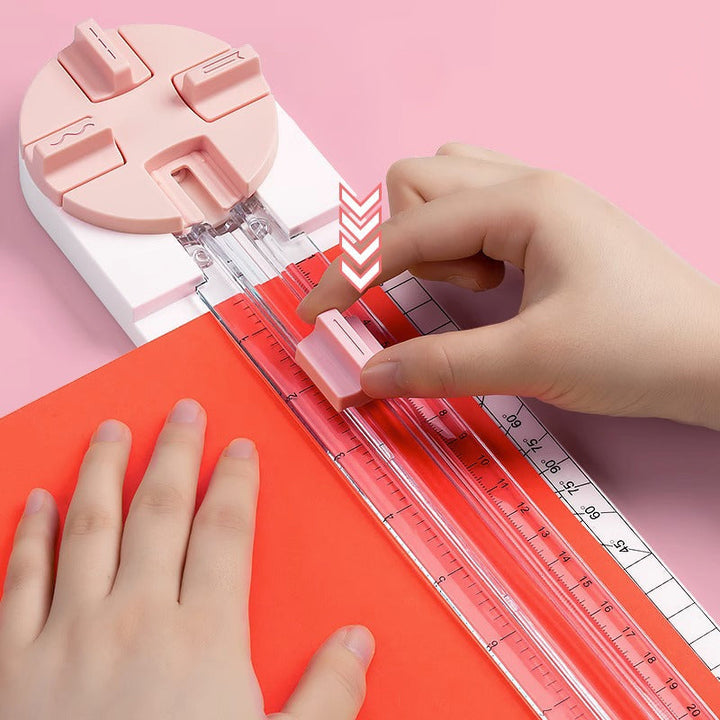 "Multifunktionell 4-i-1 pappersskärare i rosa och blå plast, perfekt för hantverk som scrapbooking med precisionsskärning."