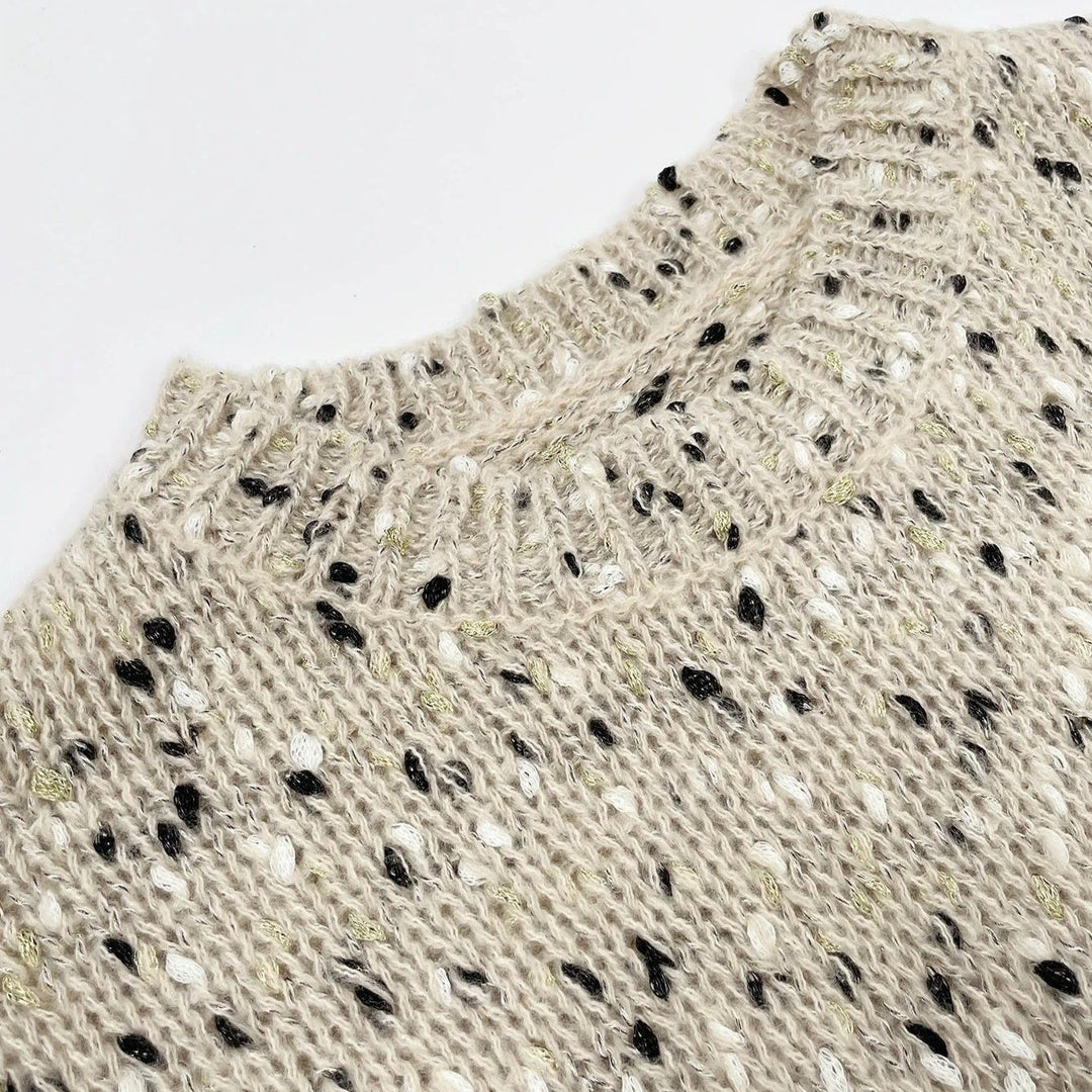 "Stickad damtröja med O-hals, prickar och drop shoulder-design, i akrylmaterial för stil och komfort."