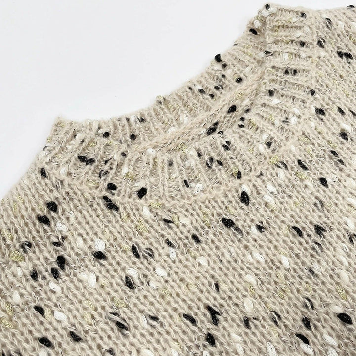 "Stickad damtröja med O-hals, prickar och drop shoulder-design, i akrylmaterial för stil och komfort."