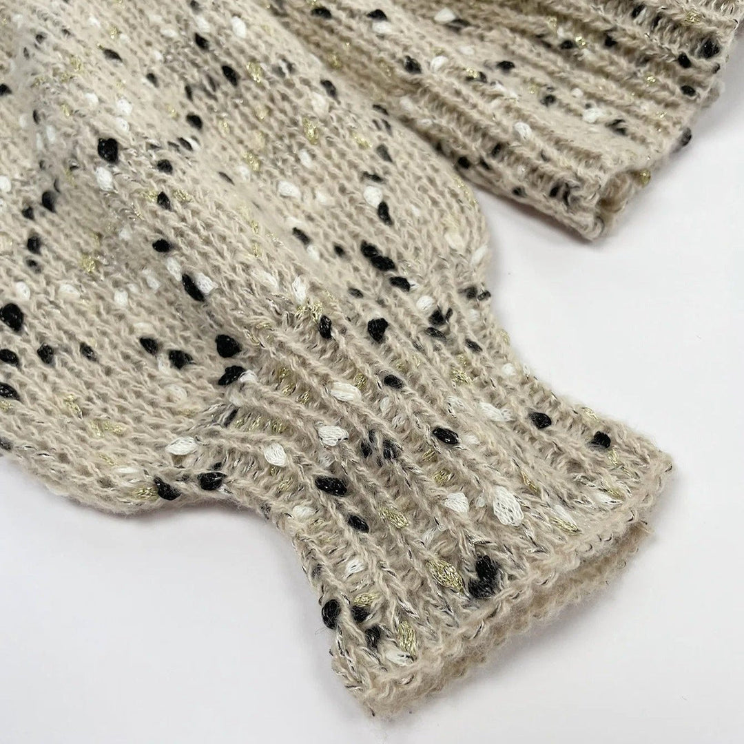 "Stickad damtröja med O-hals, prickar och drop shoulder-design, i akrylmaterial för stil och komfort."