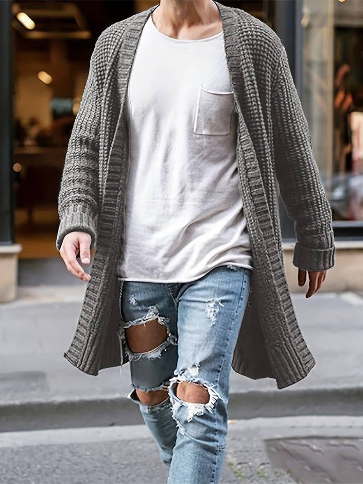 "Stickad herr cardigan i mjukt material med minimalistisk design, visad framifrån med klassiskt knappslut och rund hals."