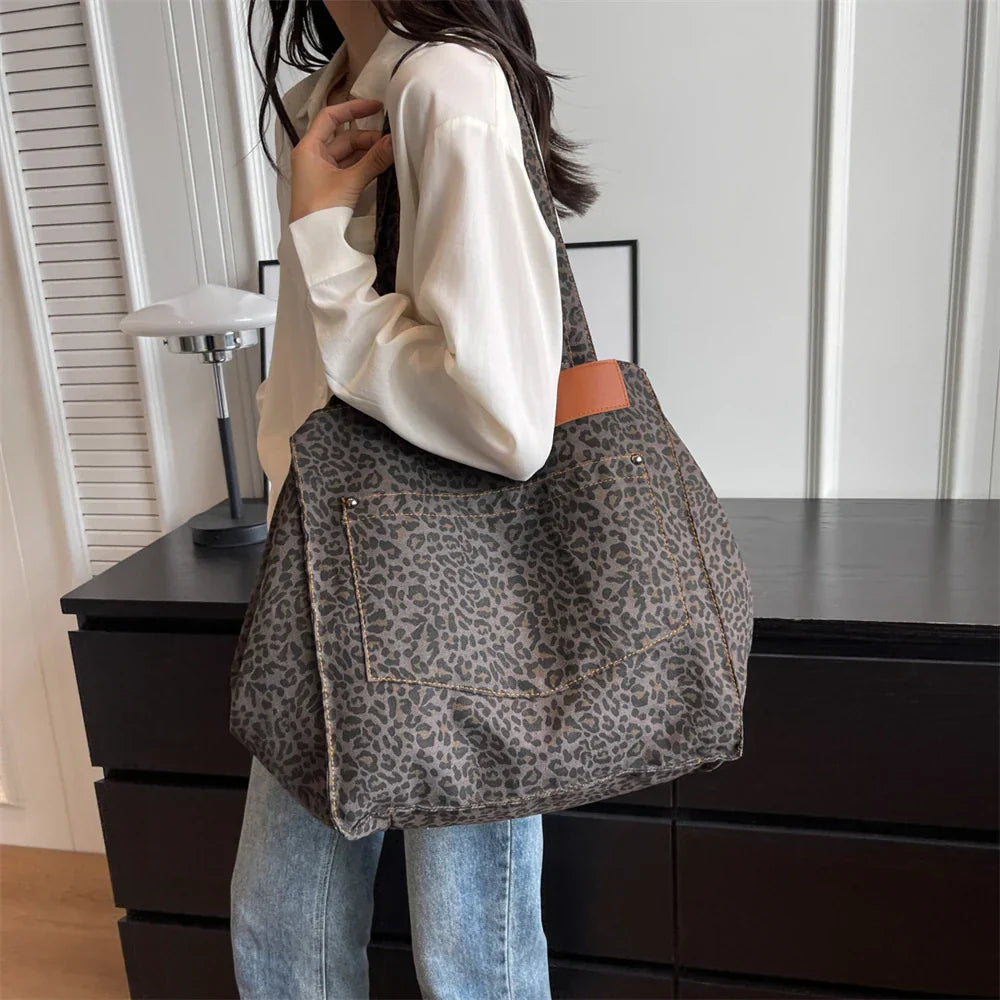 "Stilren damoversized axelväska i leopardmönstrad canvas med stora fickor, perfekt accessoar för en djärv och praktisk look."