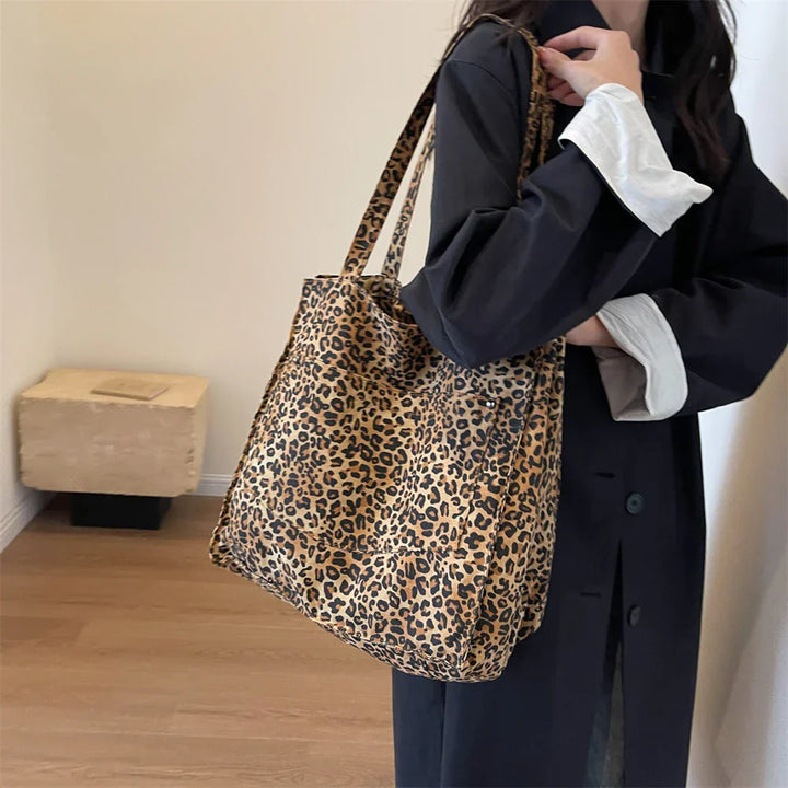 "Stilren damoversized axelväska i leopardmönstrad canvas med stora fickor, perfekt accessoar för en djärv och praktisk look."