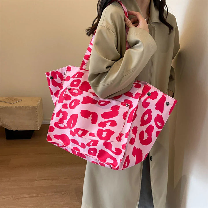"Stilren damoversized axelväska i leopardmönstrad canvas med stora fickor, perfekt accessoar för en djärv och praktisk look."