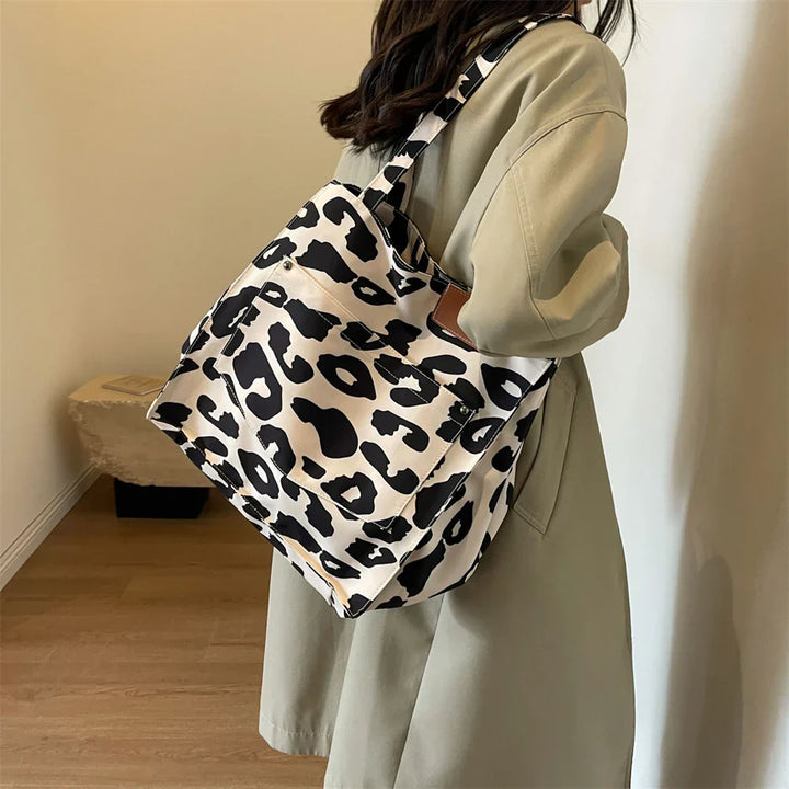 "Stilren damoversized axelväska i leopardmönstrad canvas med stora fickor, perfekt accessoar för en djärv och praktisk look."