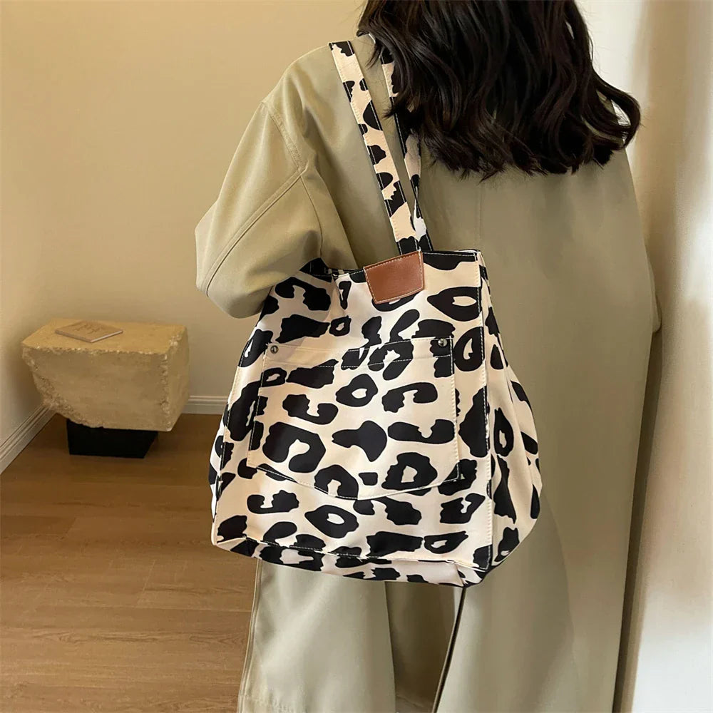 "Stilren damoversized axelväska i leopardmönstrad canvas med stora fickor, perfekt accessoar för en djärv och praktisk look."