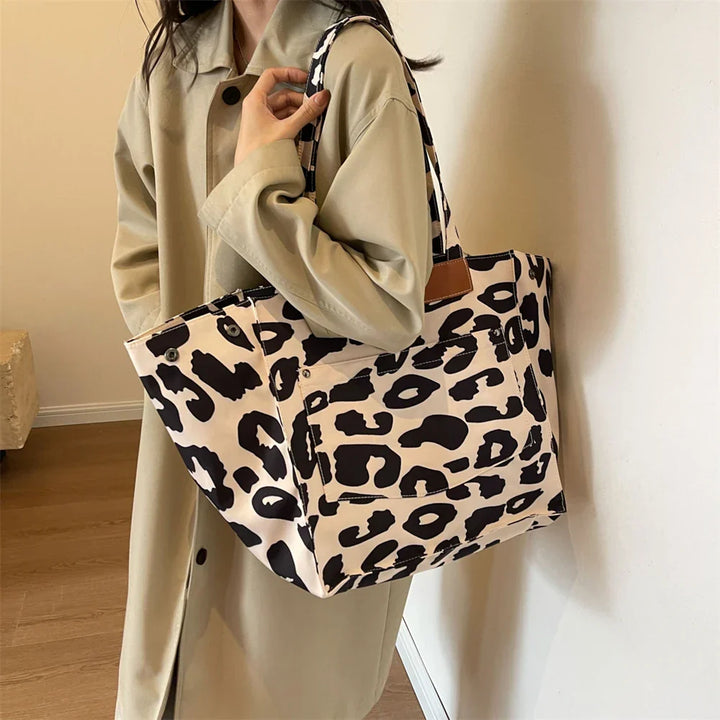 "Stilren damoversized axelväska i leopardmönstrad canvas med stora fickor, perfekt accessoar för en djärv och praktisk look."