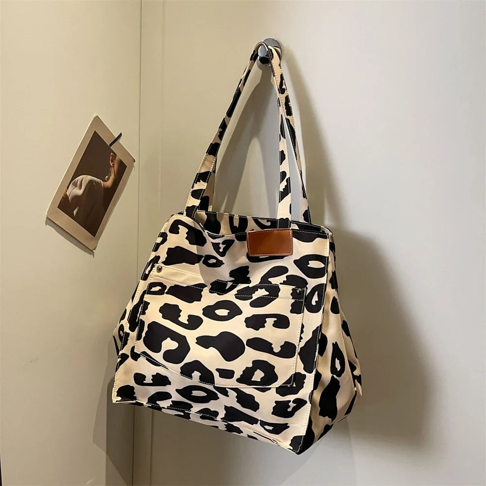"Stilren damoversized axelväska i leopardmönstrad canvas med stora fickor, perfekt accessoar för en djärv och praktisk look."