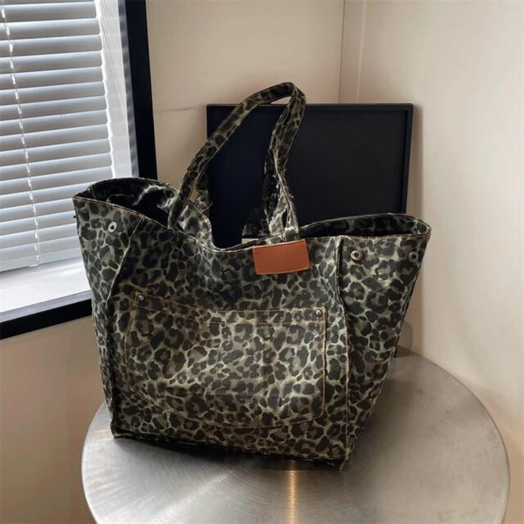 "Stilren damoversized axelväska i leopardmönstrad canvas med stora fickor, perfekt accessoar för en djärv och praktisk look."