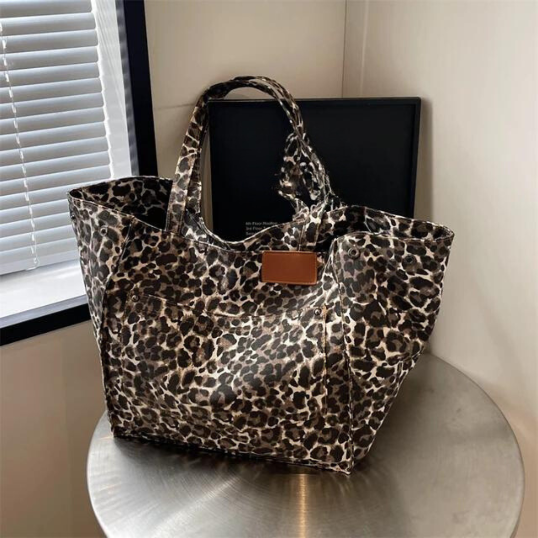 "Stilren damoversized axelväska i leopardmönstrad canvas med stora fickor, perfekt accessoar för en djärv och praktisk look."