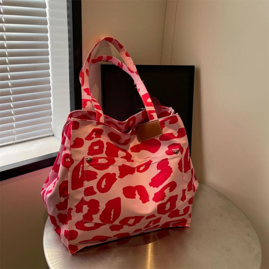 "Stilren damoversized axelväska i leopardmönstrad canvas med stora fickor, perfekt accessoar för en djärv och praktisk look."