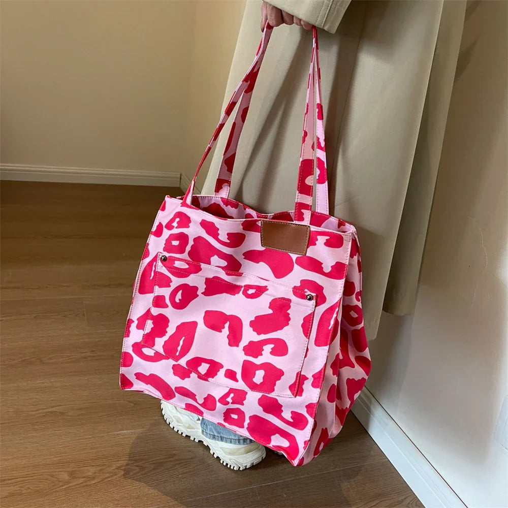 "Stilren damoversized axelväska i leopardmönstrad canvas med stora fickor, perfekt accessoar för en djärv och praktisk look."