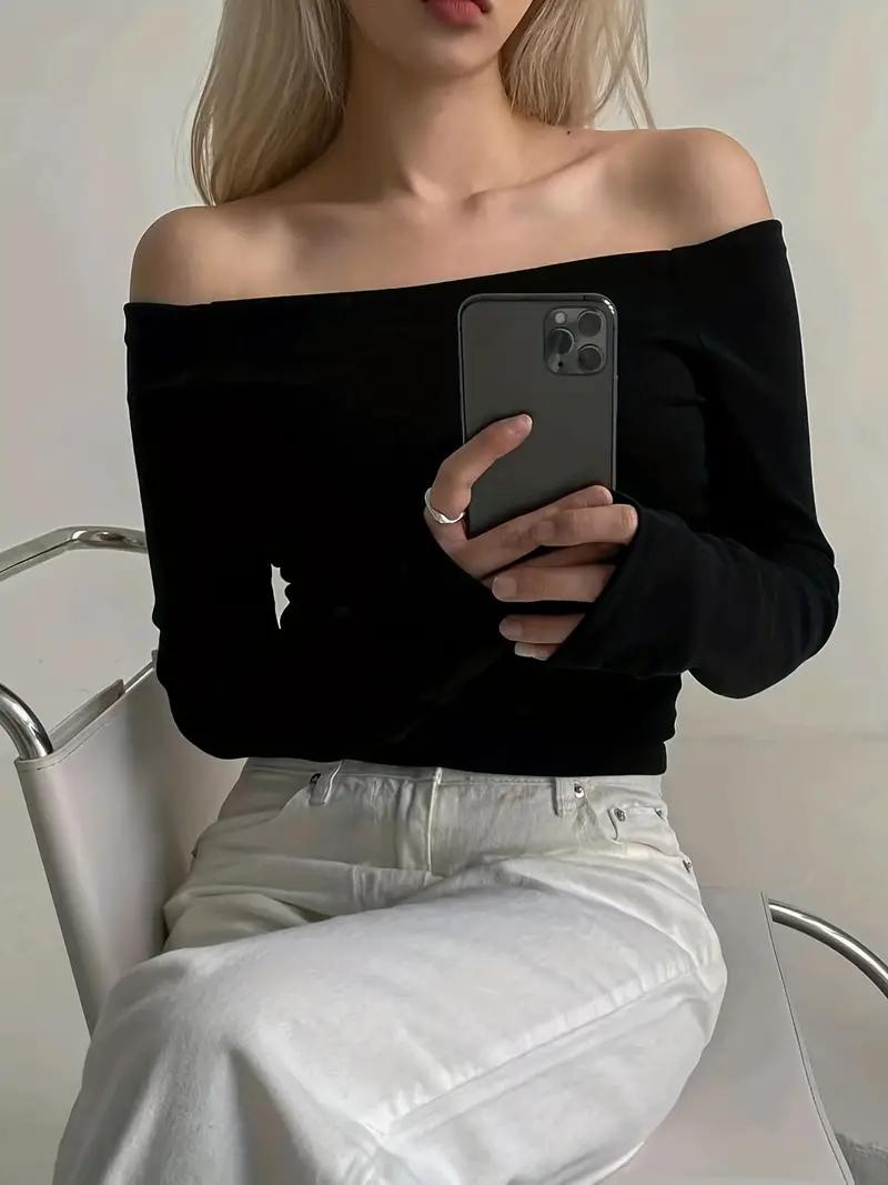 "Svart dam off-shoulder topp med långa ärmar, elastisk halsringning och bekvämt material, idealisk för många tillfällen."