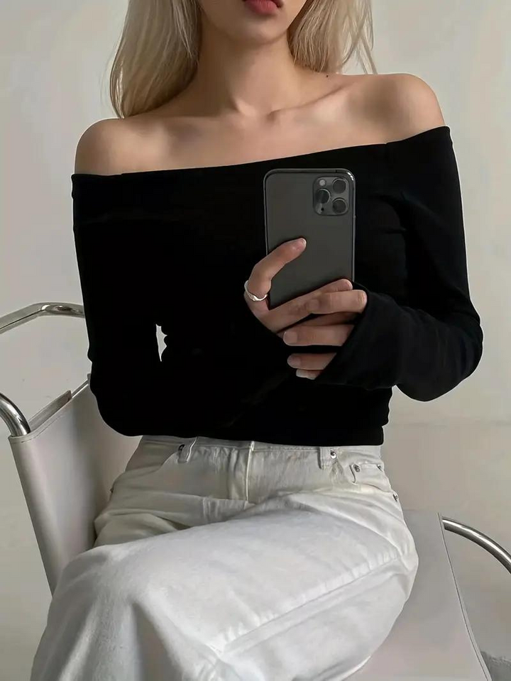 "Svart dam off-shoulder topp med långa ärmar, elastisk halsringning och bekvämt material, idealisk för många tillfällen."
