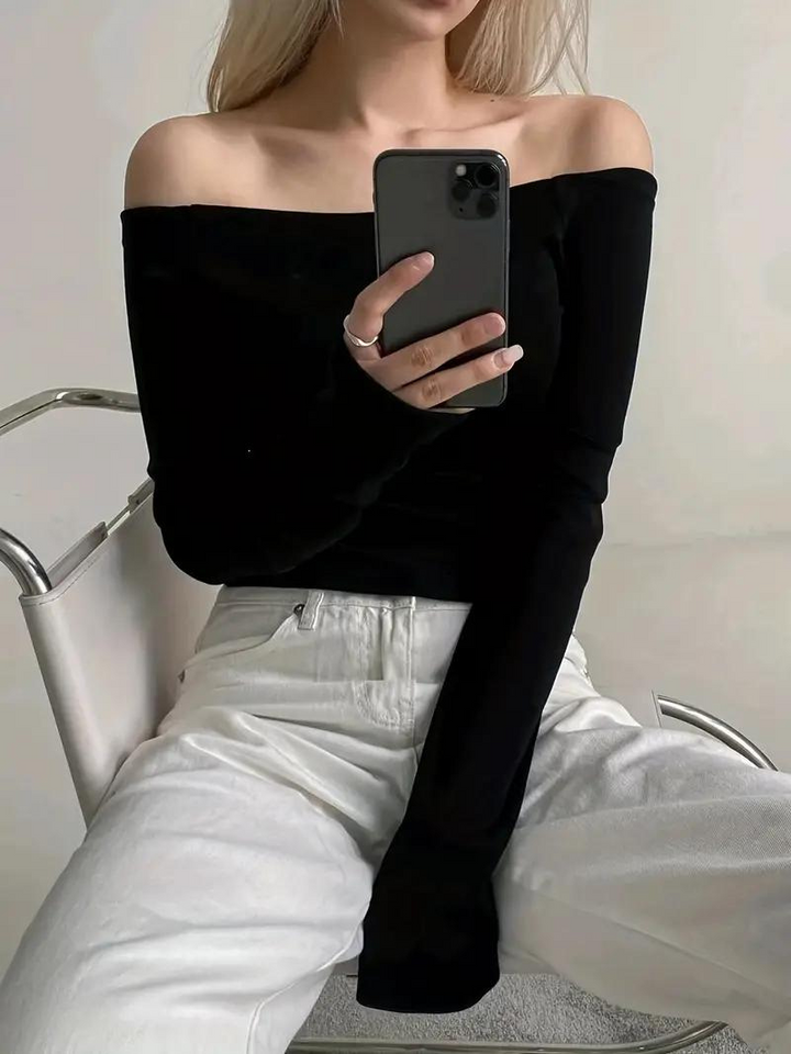 "Svart dam off-shoulder topp med långa ärmar, elastisk halsringning och bekvämt material, idealisk för många tillfällen."