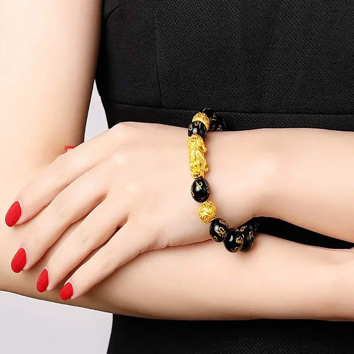 "Svart obsidian armband med Pi Xiu-detaljer, eleganta pärlor för rikedom och skydd, perfekt damaccessoar."