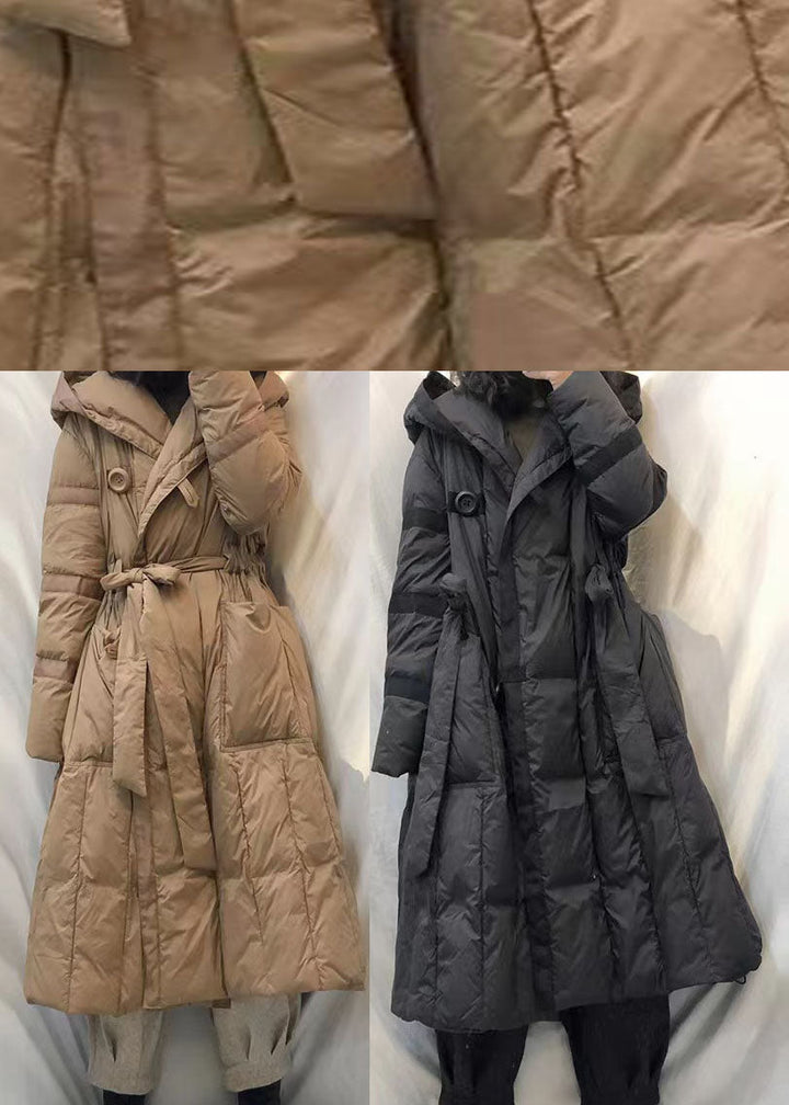 "Svart vindtät damjacka med avtagbar huva, stilren design och praktiska fickor för vinterbruk."