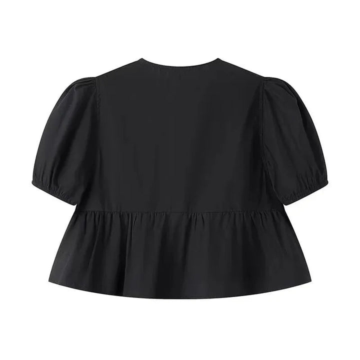 "Svartvit ruffle crop top med framtid rosett, puffärmar och elegant design, perfekt för kvinnor som älskar stilrena toppar."