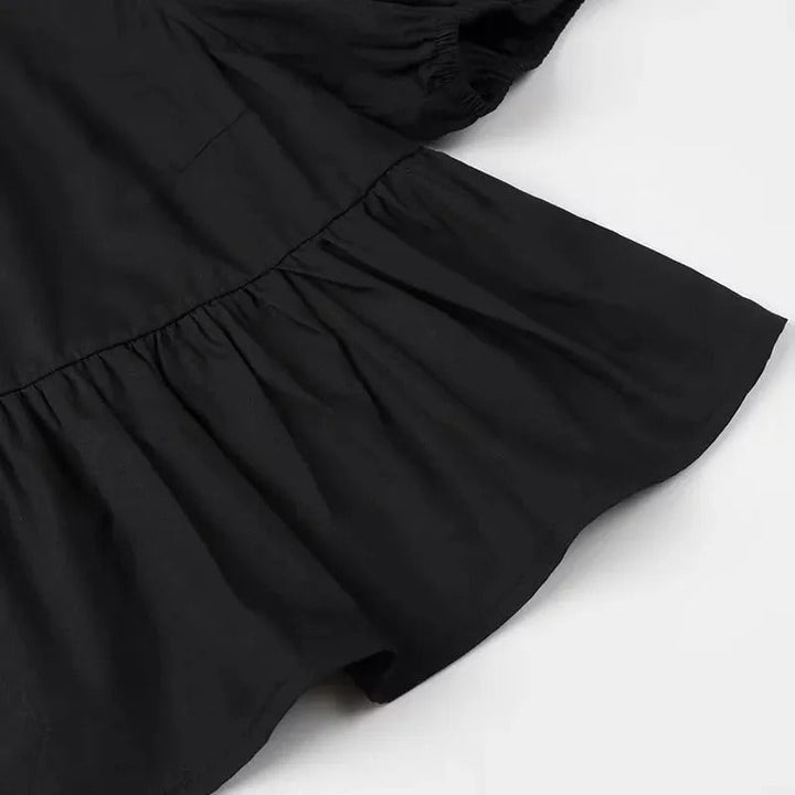 "Svartvit ruffle crop top med framtid rosett, puffärmar och elegant design, perfekt för kvinnor som älskar stilrena toppar."