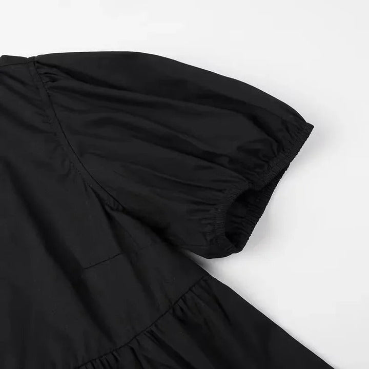 "Svartvit ruffle crop top med framtid rosett, puffärmar och elegant design, perfekt för kvinnor som älskar stilrena toppar."