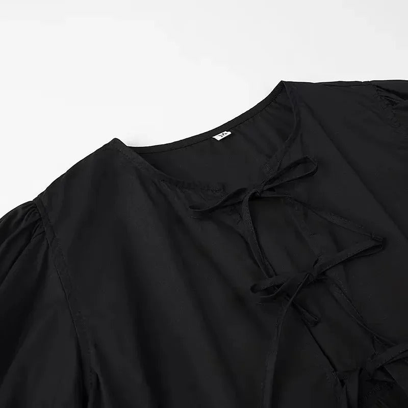 "Svartvit ruffle crop top med framtid rosett, puffärmar och elegant design, perfekt för kvinnor som älskar stilrena toppar."
