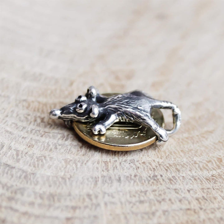 "Talisman i legering med muscharm, rund design med detaljrik mus på mynt. Accessoar ger lycka, skydd och stil."